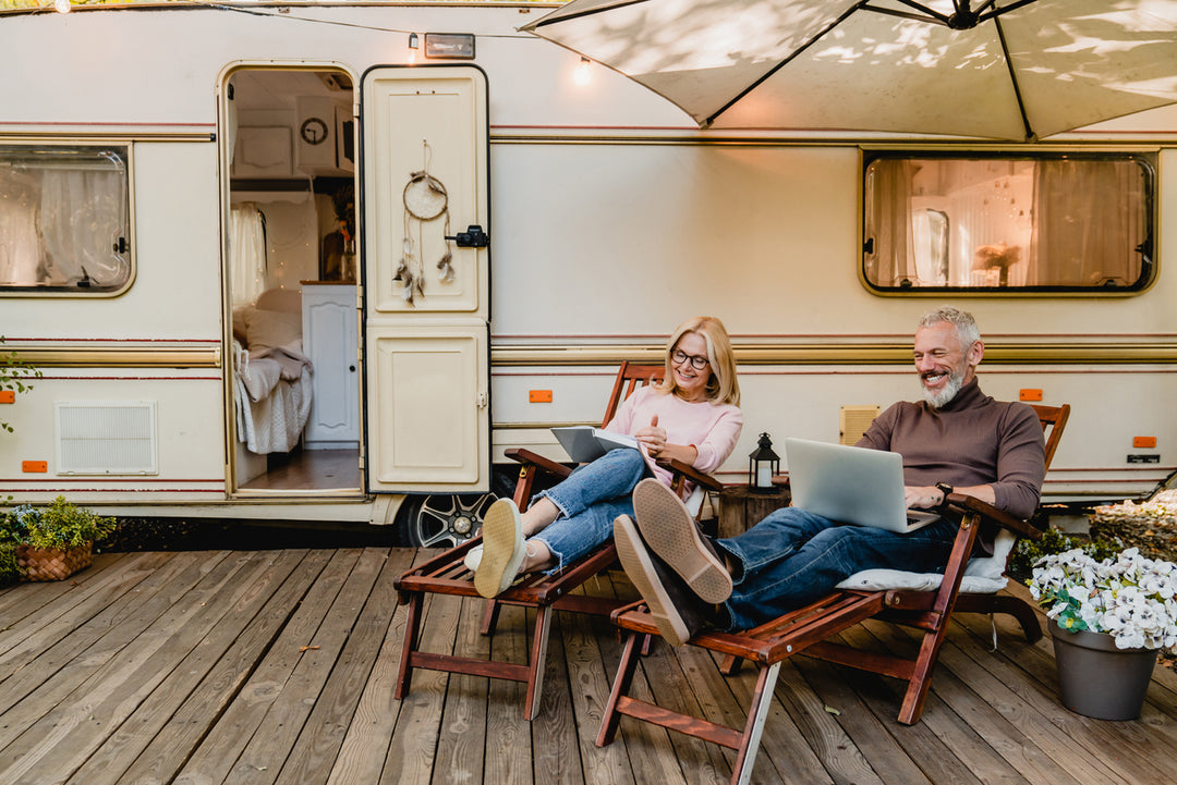 A couple outside of their RV enjoying their seamless RV internet connection 