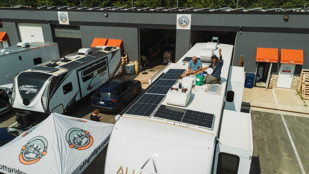 Aerial view of technicians installing solar panels on an RV roof outside the Off Grid Power Systems workshop.