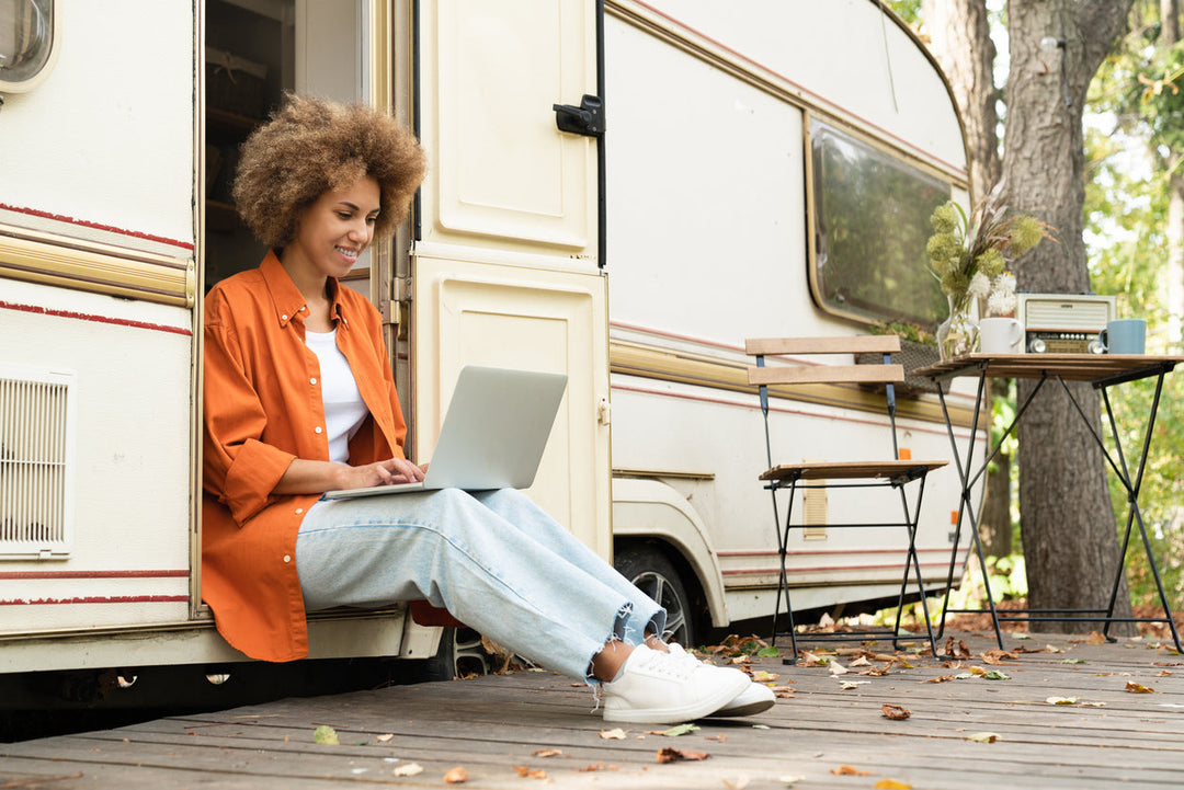 Woman working on her laptop outside of her RV