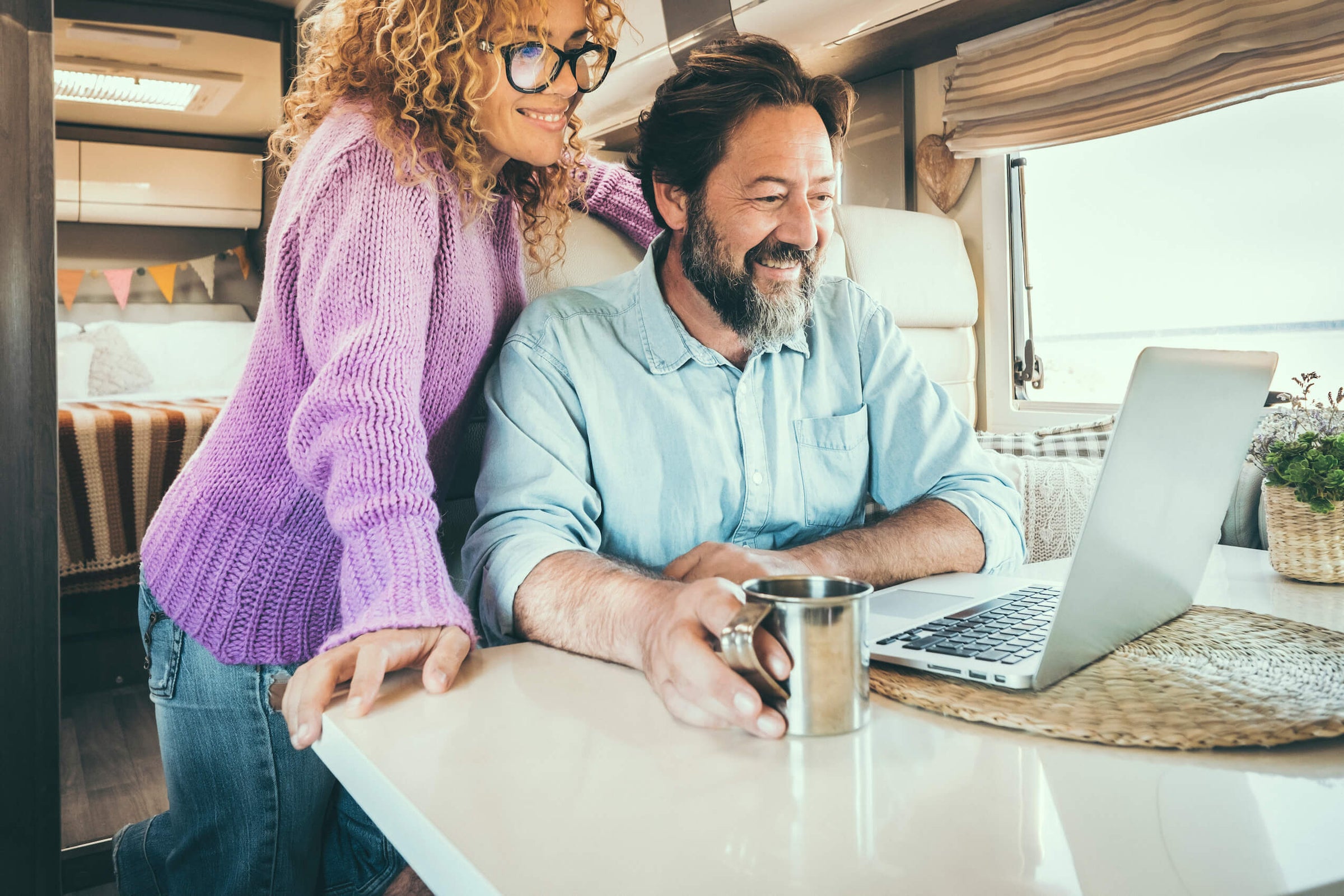 couple in their rv looking at a laptop